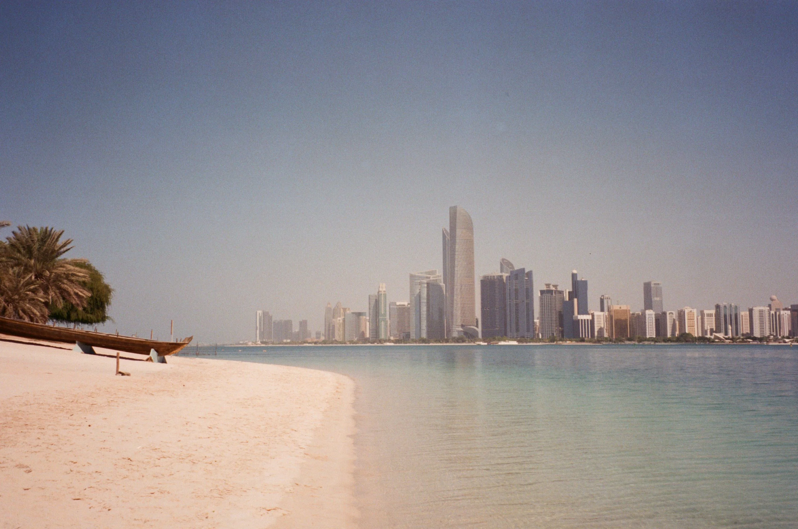 Abu Dhabi skyline seen from a quiet sandy beach