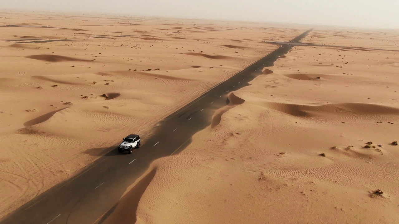 A 4x4 driving along a desert road during the Seven Emirates Tour.